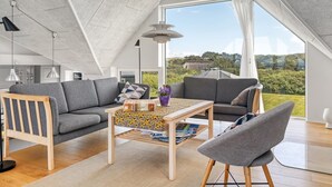Un dormitorio tipo loft moderno con techo inclinado, un ventanal y vistas al exterior.