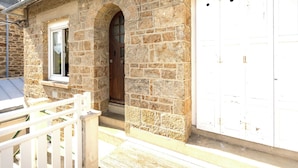 A stone building with a wooden door and a window. - Theophile by Interhome (Saint Malo)
