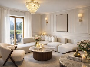 A modern living room with a sectional sofa, a round coffee table, and a chandelier.
