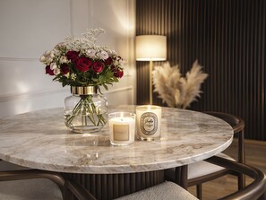 Una mesa redonda de mármol con un florero y dos velas.