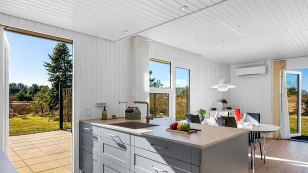 A modern kitchen with a large island, a dining area, and a view of the outdoors. - "Sinikka" - 900m from the sea by Interhome (Blåvand)