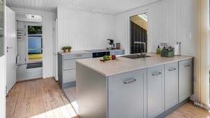 A modern kitchen with a large island, built-in appliances, and a view to the outdoors. - "Sinikka" - 900m from the sea by Interhome (Blåvand)