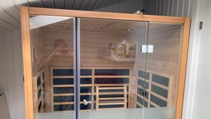 A room with a wooden cabinet, a glass partition, and a metal door. - "Sinikka" - 900m from the sea by Interhome (Blåvand)