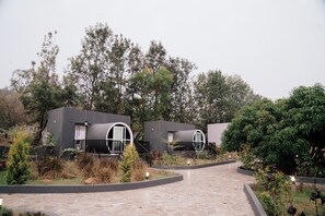 Een modern gebouw met gebogen ramen en een pad van stenen dat ernaartoe leidt.