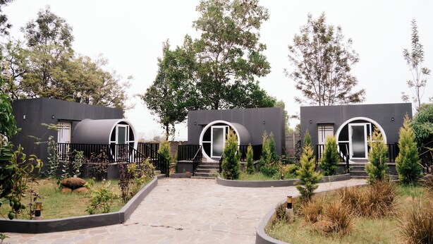 A modern building with circular windows and a paved pathway leading to the entrance. - Benchkal Resort (Tumkur)