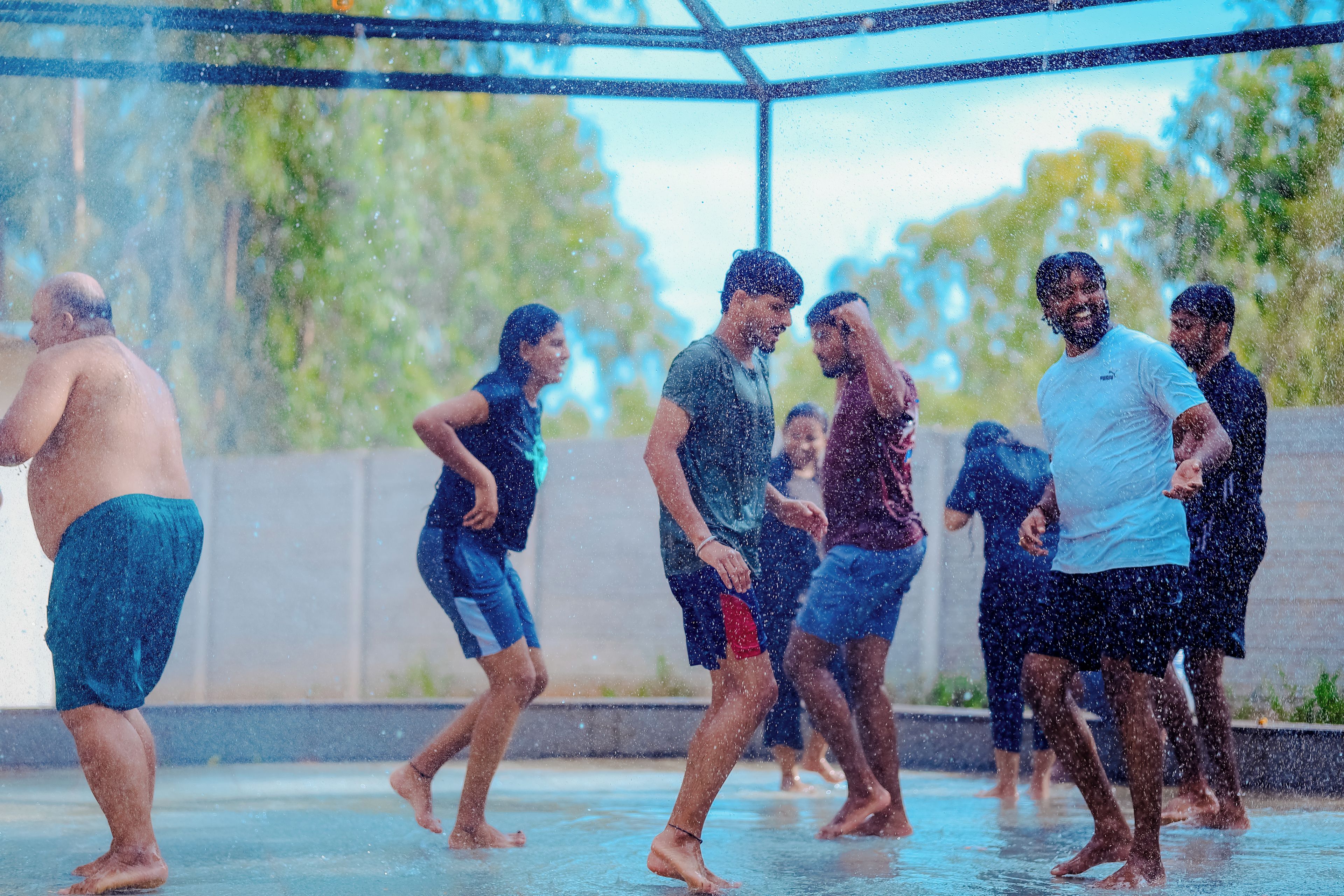 A group of people in a water feature area with a clear sky in the background.