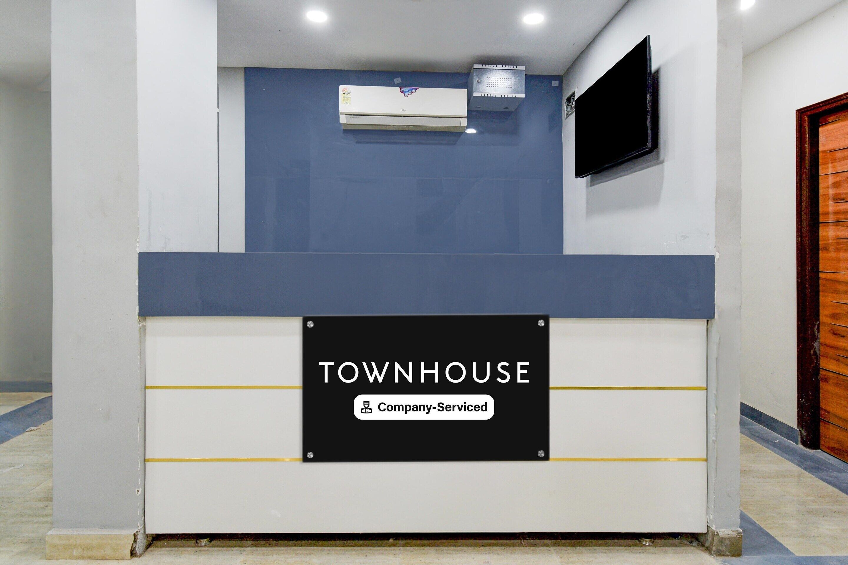 A reception desk with a sign reading 'TOWNHOUSE Company Serviced.'