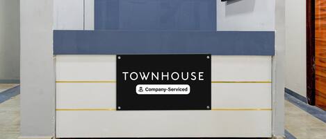A reception desk with a sign reading 'TOWNHOUSE Company Serviced.'