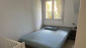 Makuuhuoneessa on yksi sänky, yöpöytä, työpöytä ja ikkuna, josta on näkymä puita kohden.