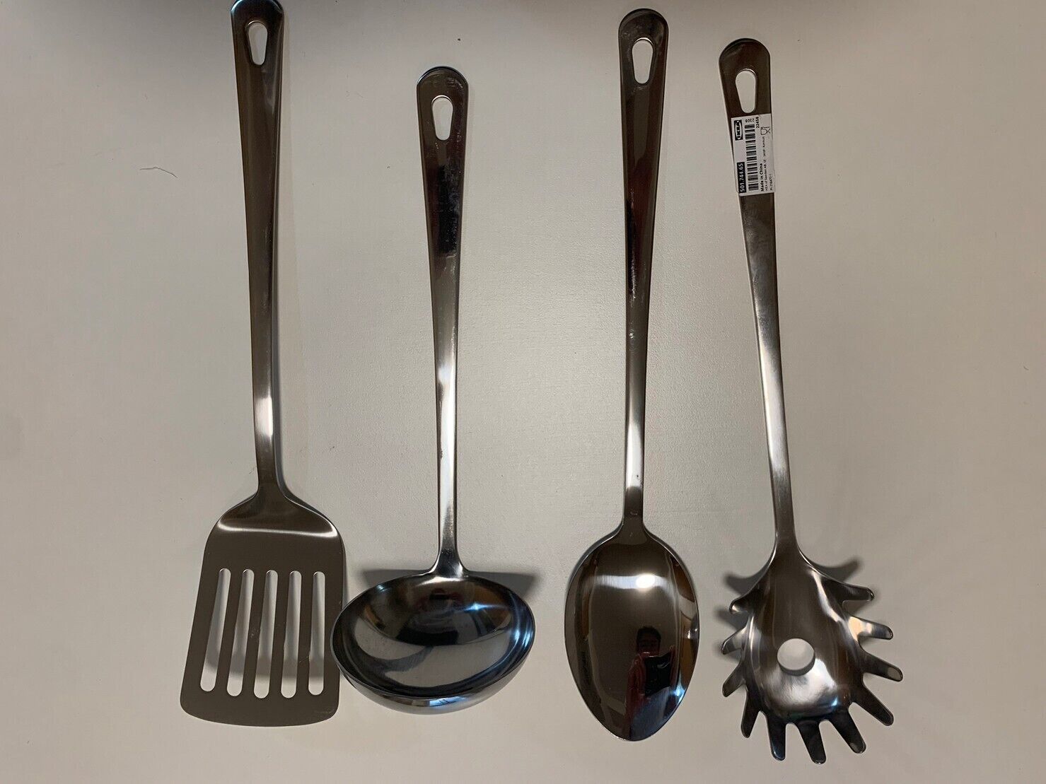 Four kitchen utensils: a spatula, a ladle, a spoon, and a slotted spoon.