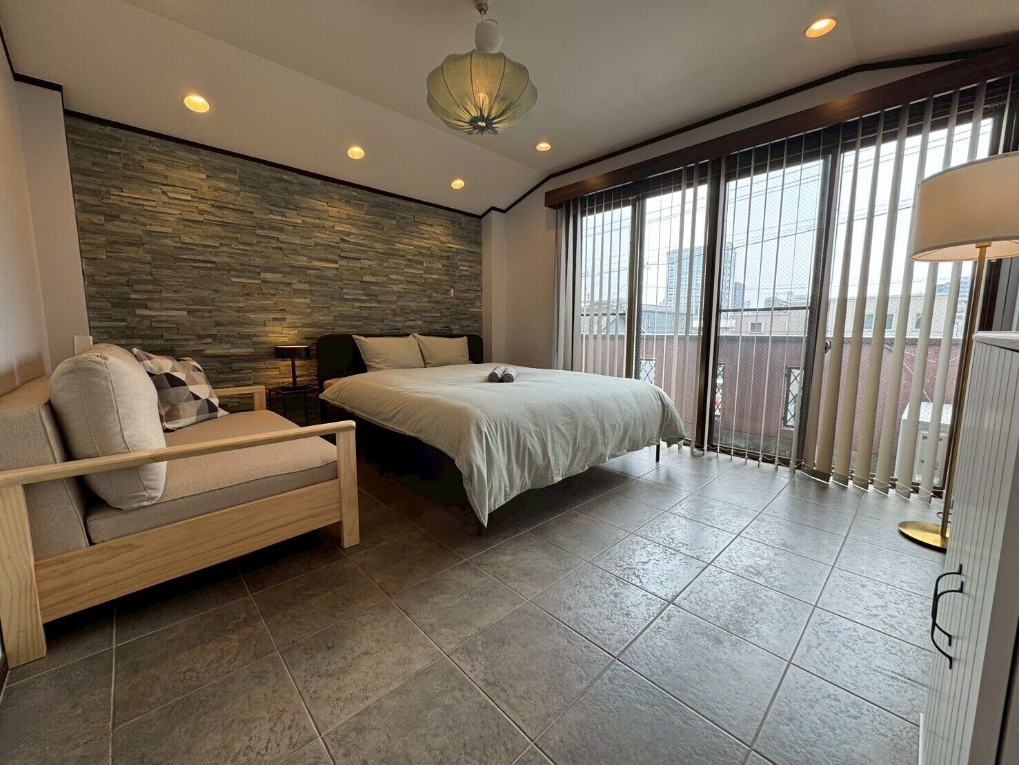 Quarto moderno com uma cama grande, um sofá e uma varanda com vista.