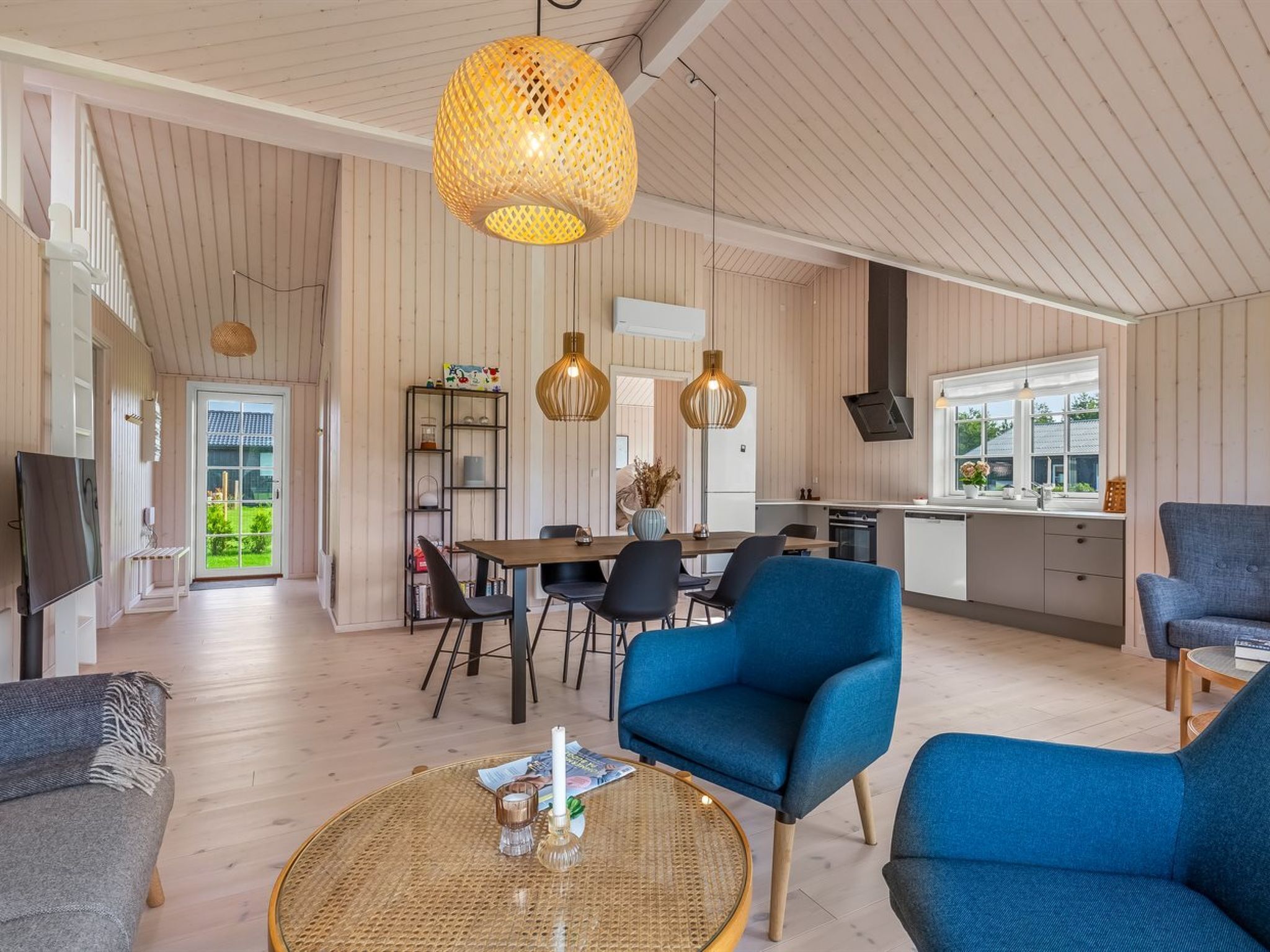 Un interior moderno con comedor, cocina y zona de estar.