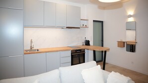A modern kitchen with grey cabinets, a wooden countertop, and a built-in oven.