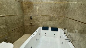 Ein modernes Badezimmer mit einer großen Badewanne, einer Toilette und einer Duschkabine.