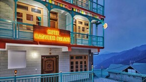 A hotel named "Hotel Ranveer Palace" with a prominent sign, a balcony with railings, and a view of mountains in the background. - Hotel Ranveer Palace (Narkanda)