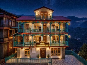 A multi-story hotel with balconies, a sign reading 'Hotel Ranveer Palace,' and a mountainous backdrop. - Hotel Ranveer Palace (Narkanda)