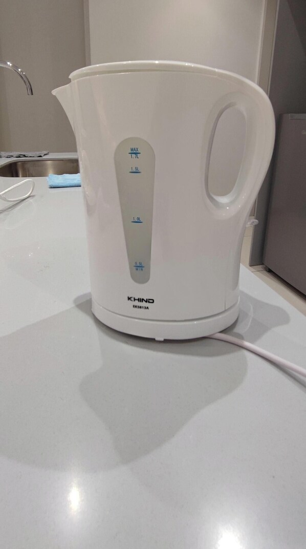 A white electric kettle with measurement markings and brand name on a countertop. - Luxury Balcony at Trion 1 KL by HCK (Kuala Lumpur)
