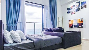 Una sala de estar moderna con un sofá cama, un televisor de pantalla plana y obras de arte en la pared.