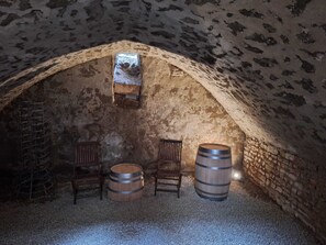 A rustic cellar with stone walls, wooden barrels, and a small wooden shelf. - Fabulous 1-bedroom studio in La Charité-sur-Loire (La Charité-sur-Loire)