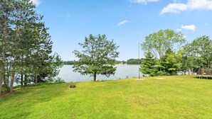 A grassy area with trees and a lake. - Lunar Lodge on Windfall Lake (Exeland)
