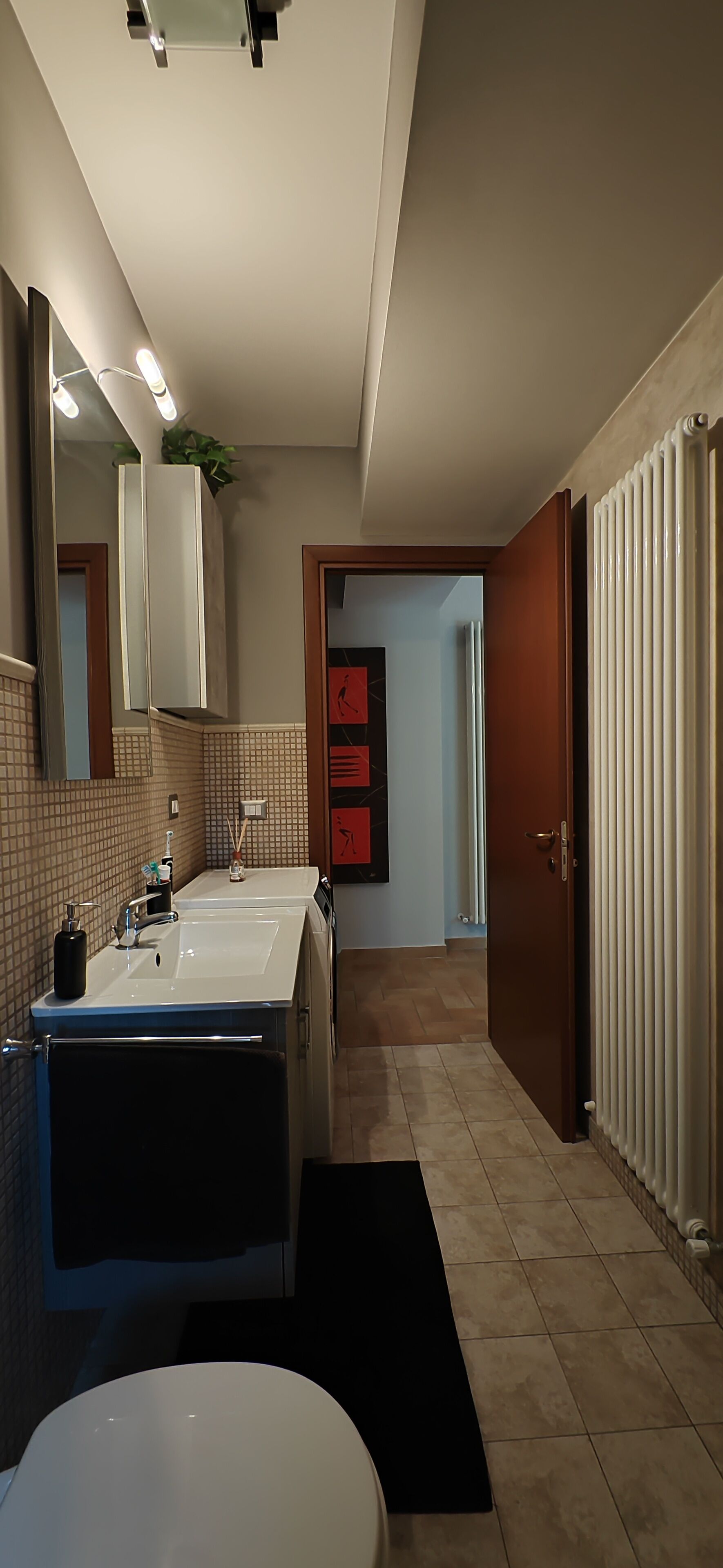 Une salle de bain moderne avec deux lavabos, un miroir et des toilettes.