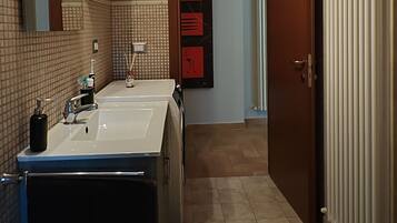 Une salle de bain moderne avec deux lavabos, un miroir et des toilettes.