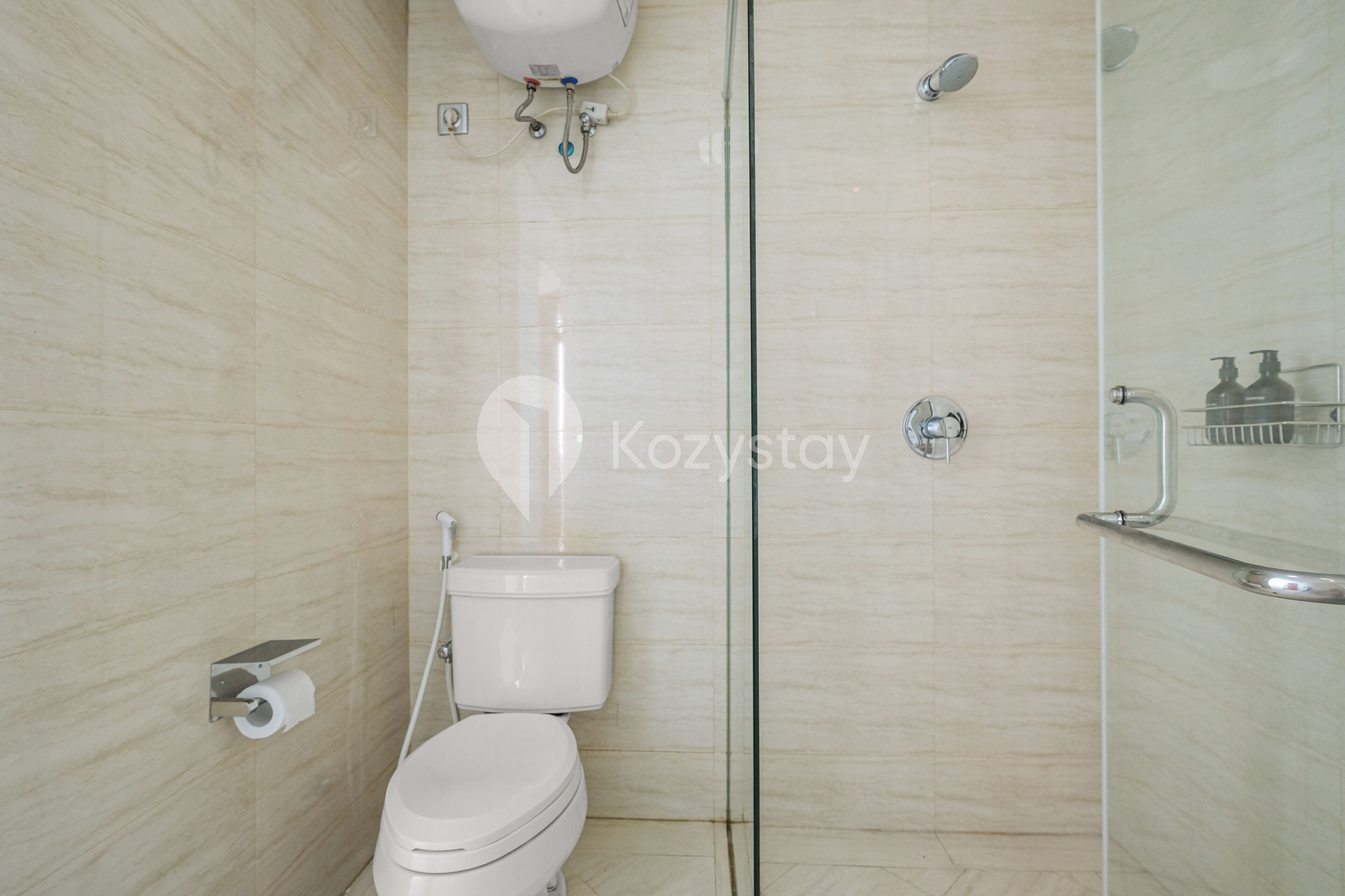 A modern bathroom with a toilet, a glass shower enclosure, and a hand dryer.