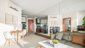 Ein modernes Wohnzimmer mit einer Couch, einem Couchtisch und einem Essbereich mit Stühlen und einem Tisch.