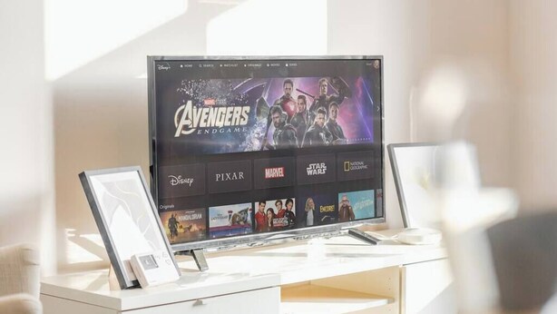 Ein Flachbildfernseher auf einem weißen Schreibtisch, wobei die Disney+-Oberfläche den Film Avengers: Endgame anzeigt.