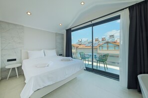A modern bedroom with a large bed, a small bedside table, and a view of the city through floor-to-ceiling windows. - KARBELSUN CITY  (Fethiye)