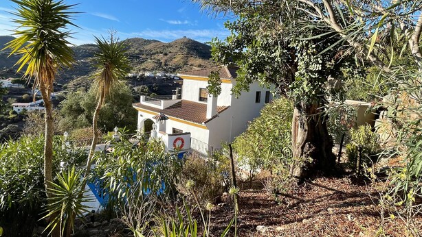 A white building with a red-tiled roof, surrounded by greenery and hills in the background. - Spanish country house. Completely free, yet two restaurants within walking distance. (COMARES)