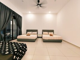 Une chambre avec deux lits, un ventilateur de plafond et une chaise.