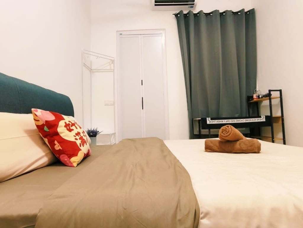 Ein Hotelzimmer mit Bett, Schreibtisch, Stuhl, einem Fenster mit Vorhängen und einer Tür.