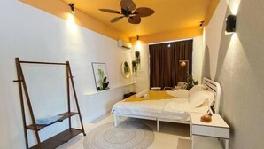 A bedroom with a bed, a nightstand, a wooden ladder, a ceiling fan, and a window with curtains. - ioic (Kulai)