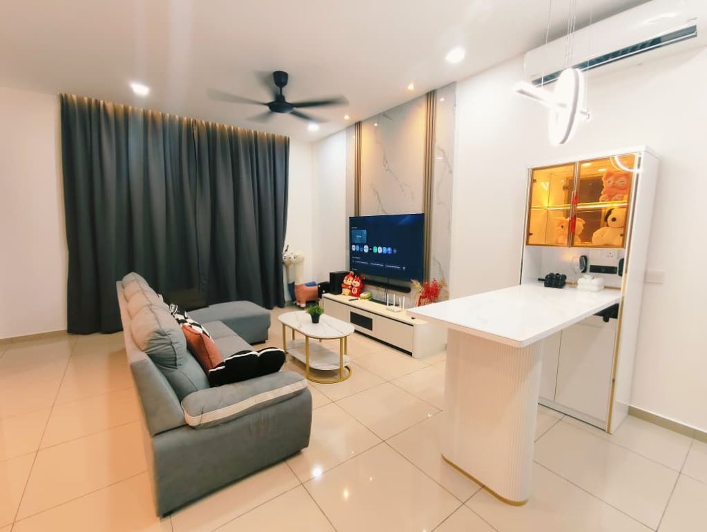 A modern living room with a sofa, a coffee table, a TV, and a small kitchen area.