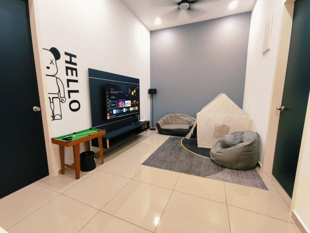 A room with a pool table, a bean bag chair, a small tent-like structure, and a wall-mounted TV.