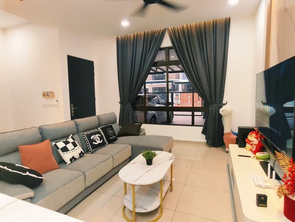 A modern living room with a grey sofa, a small round table, and a TV.