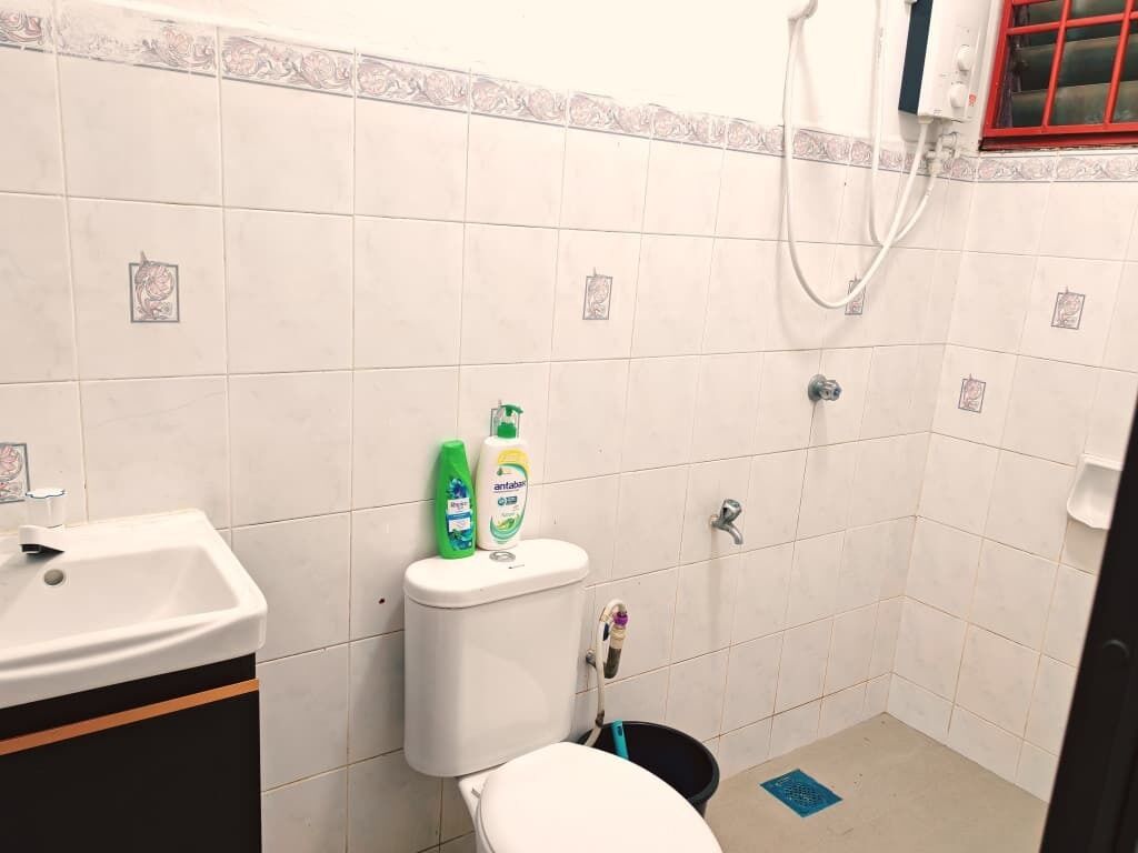 Une petite salle de bain avec des toilettes, un lavabo et une douche.