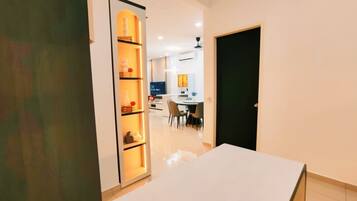 Un interior moderno con una mesa blanca, una zona de cocina y un comedor.
