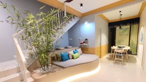 A modern living area with a curved sofa, a staircase, and a dining table. - ioic (Kulai)