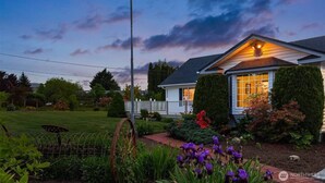 Uma casa com um jardim bem cuidado, um deck de madeira e uma grande janela.