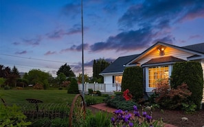 A house with a well-maintained garden, a wooden deck, and a large window. - Snohomish 10+Acre 5BR | Hot Tub, Pond & Stables (Snohomish)