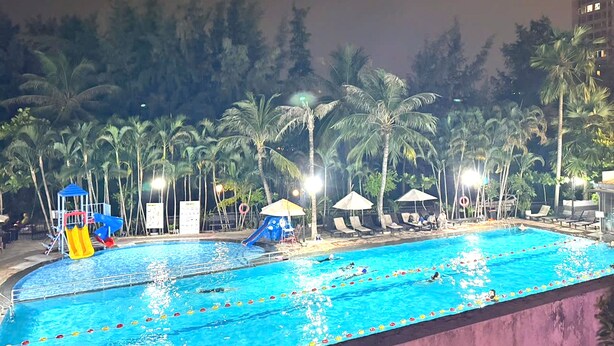 A swimming pool with a water slide and lounge chairs. - Sky Garden 3 (Ho Chi Minh City)