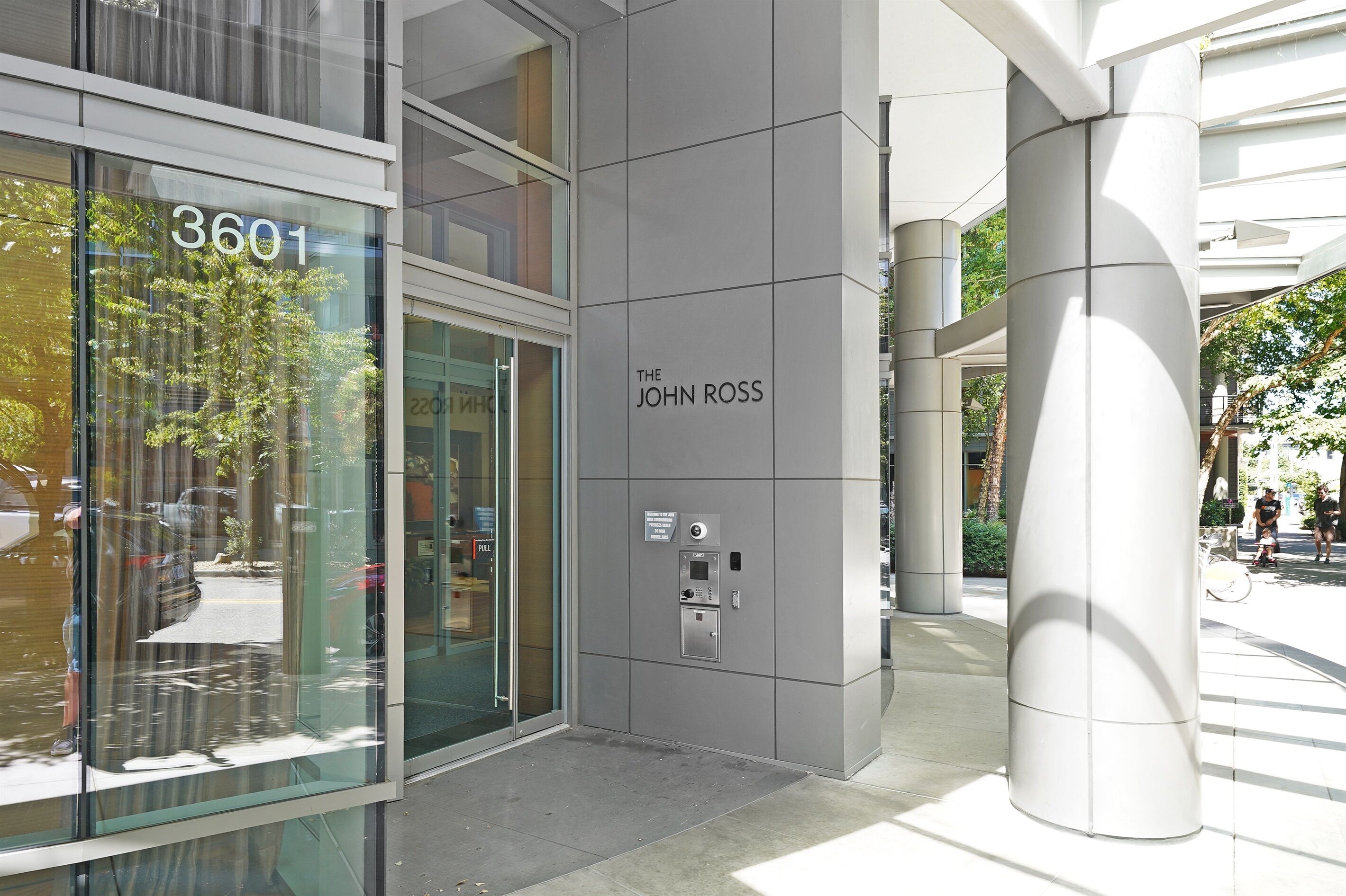 A modern building with a glass facade, a sign reading "3601", and a plaque that says "The John Ross".