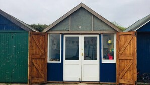 A small building with a gabled roof, two white doors, and a number 31 on the front. - Comfy Holiday Home & Beach Hut (Sutton on Sea)