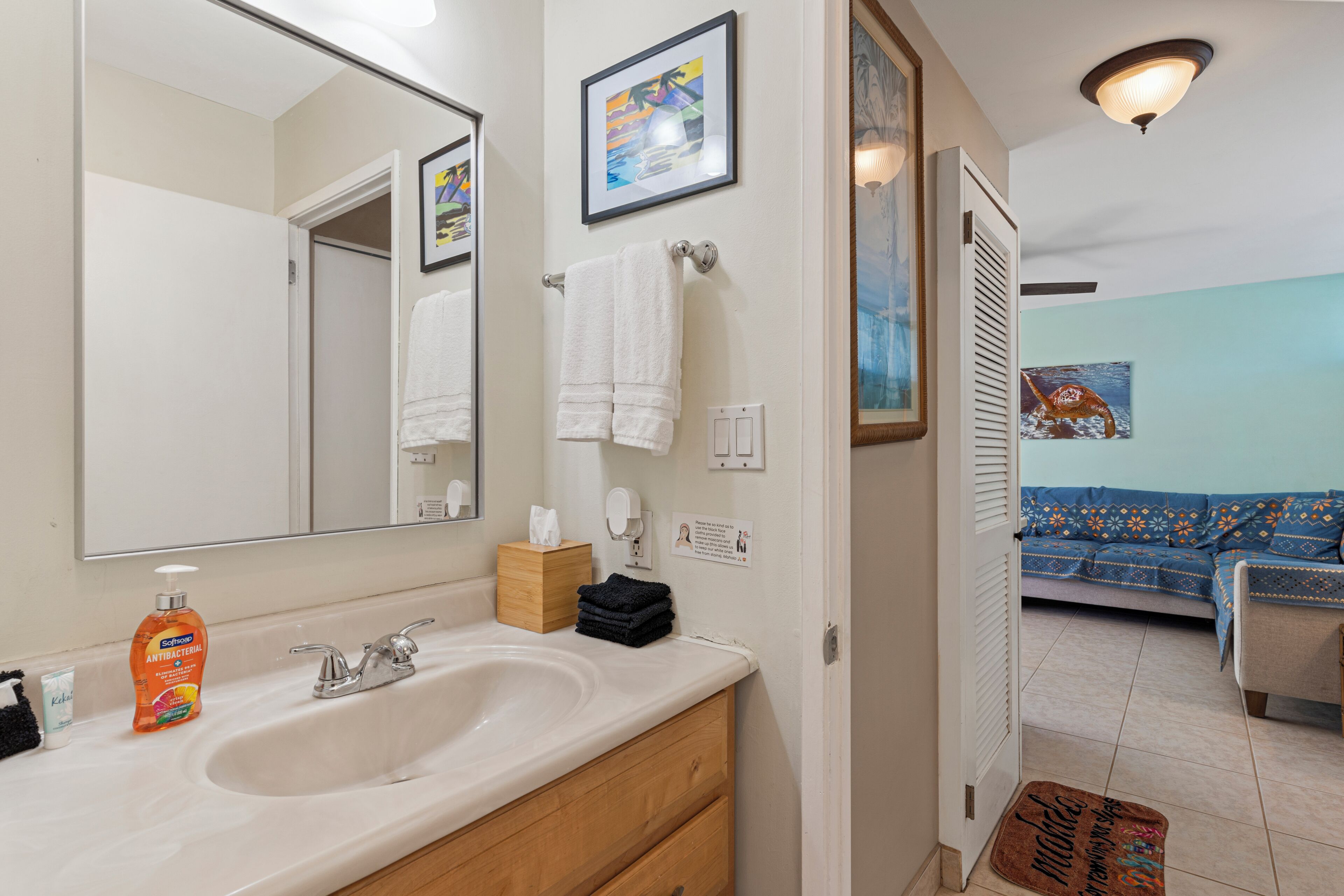 A bathroom with a sink, mirror, and a towel rack.