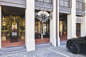 A building entrance with a sign reading 'PARADIS' and another sign for 'MERCADO' at 82 South Barret Square.
