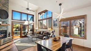 A spacious living area with a fireplace, a dining table, and a sofa.