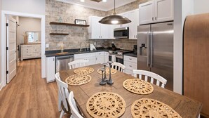 Een moderne keuken met witte kastjes, een roestvrijstalen koelkast en een houten plafond.
