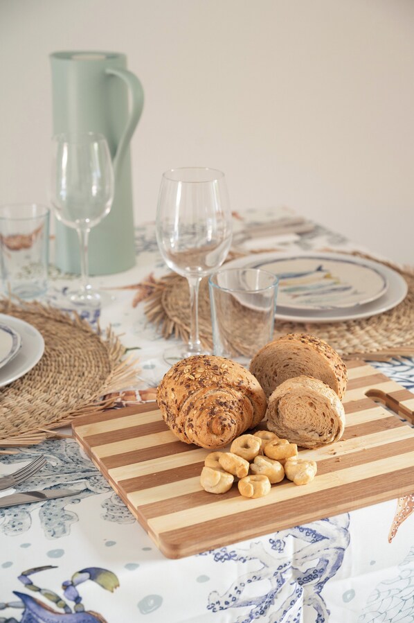 A table set with bread, nuts, and wine glasses, suggesting a meal setting. - Casa Esmeralda your Sardinian hideaway, 4 mins from paradise beaches (San Teodoro)